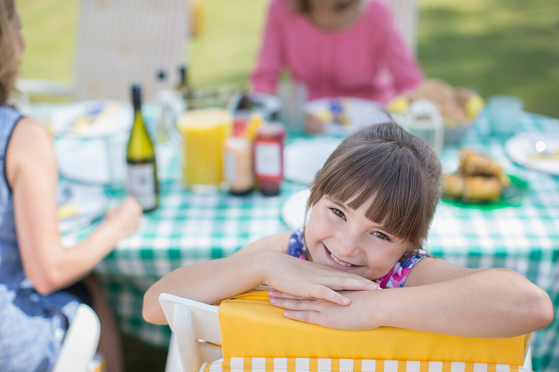 Girl smiling at table in backyard