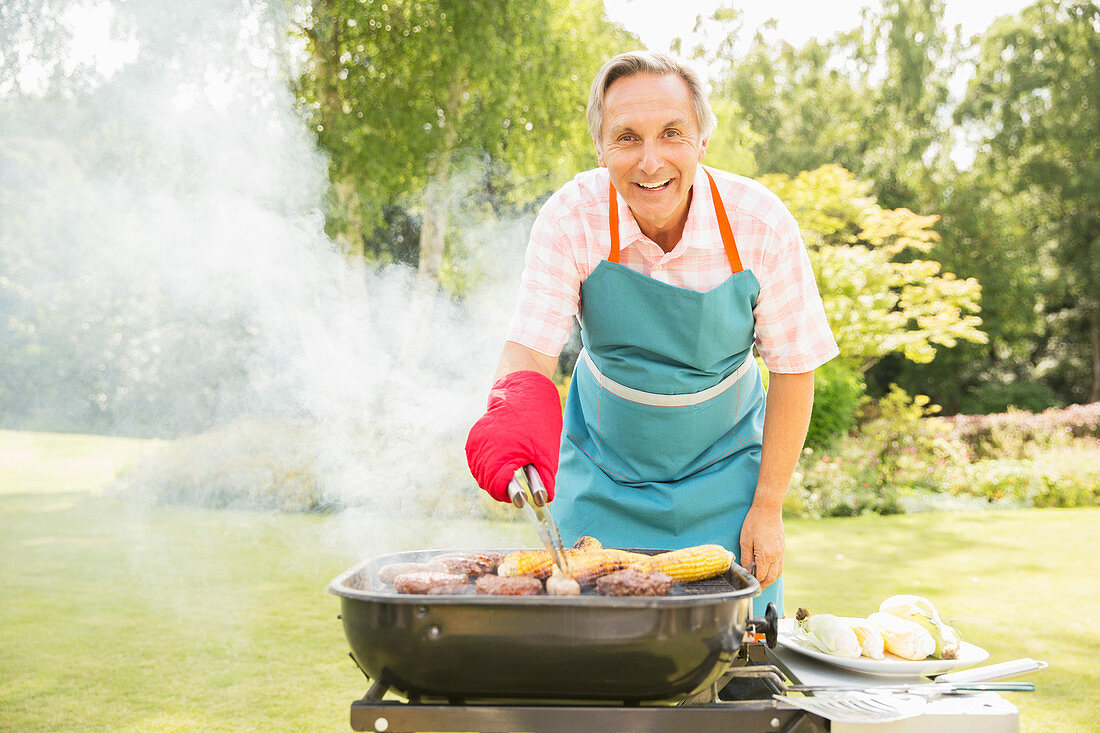 Man grilling food on barbecue in backyard