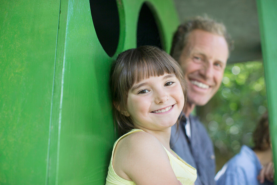 Father and daughter smiling in treehouse