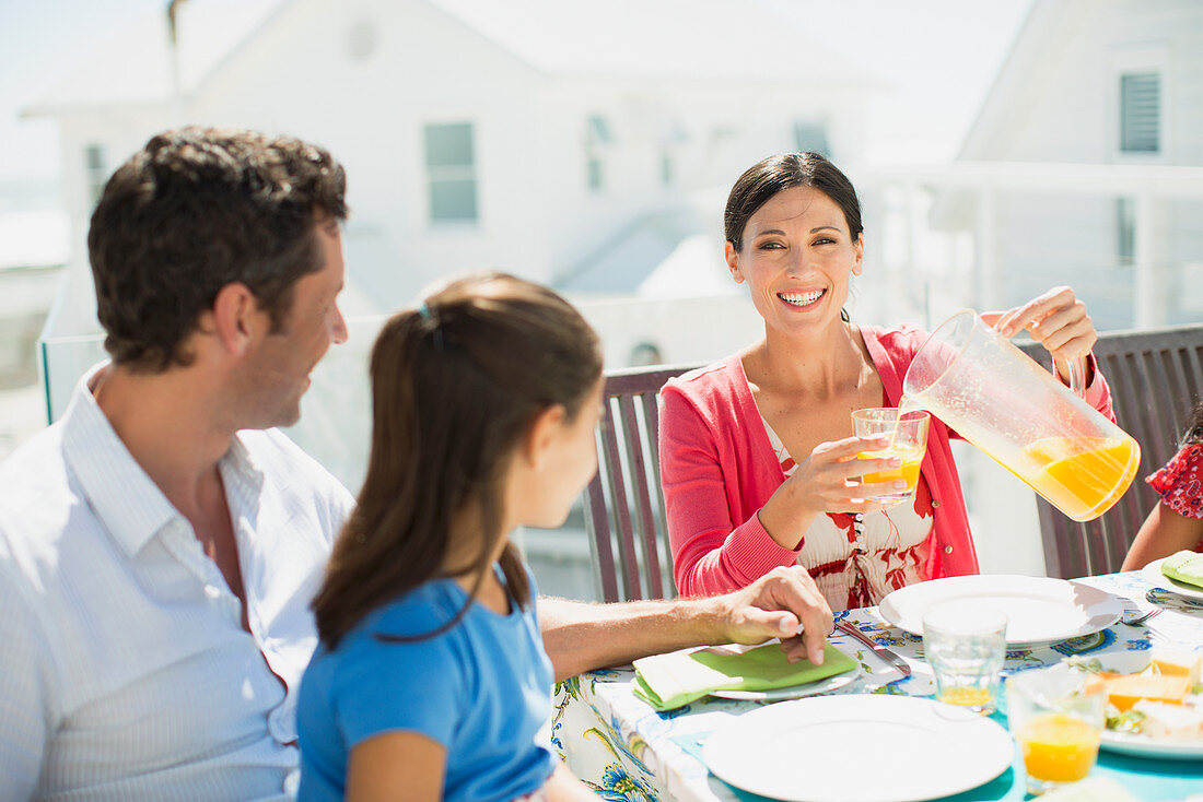 Family eating breakfast on sunny patio