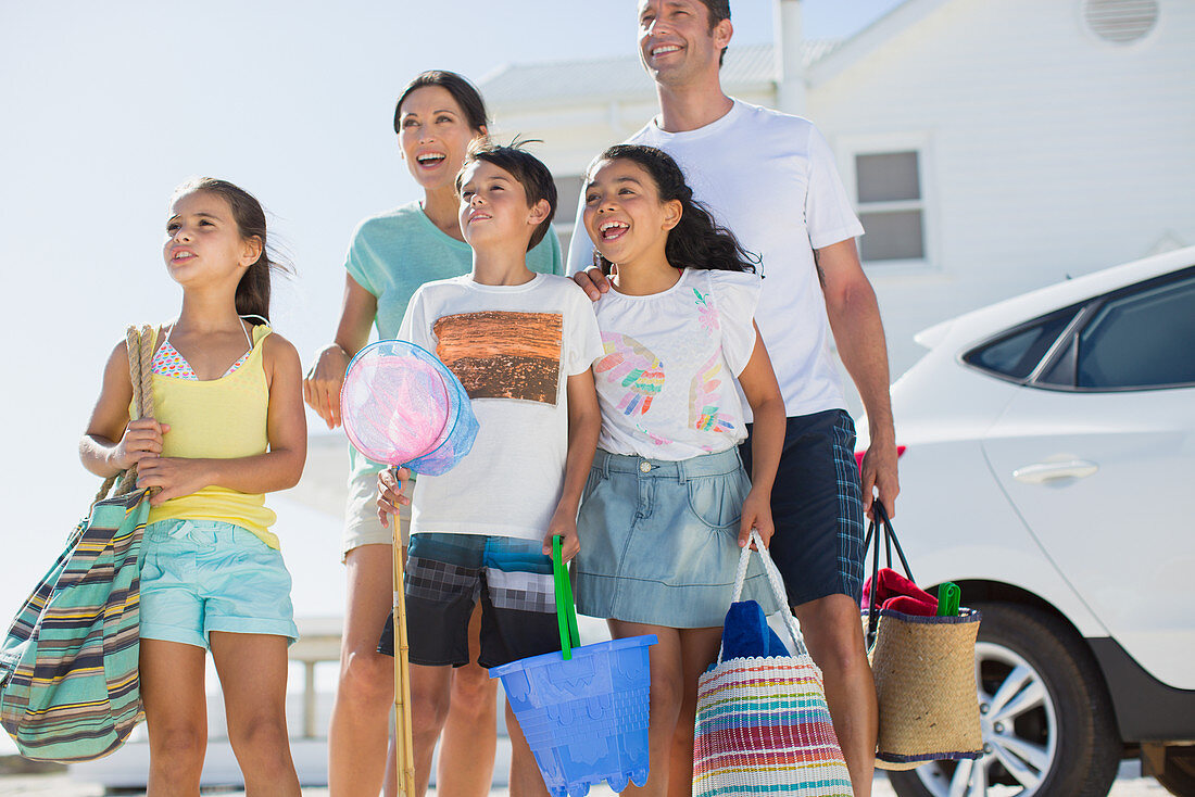 Family standing with beach gear