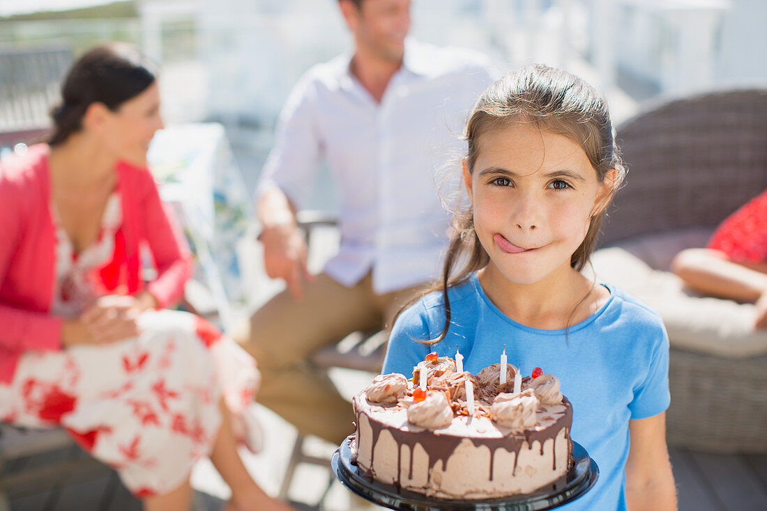 Girl with birthday cake licking lips