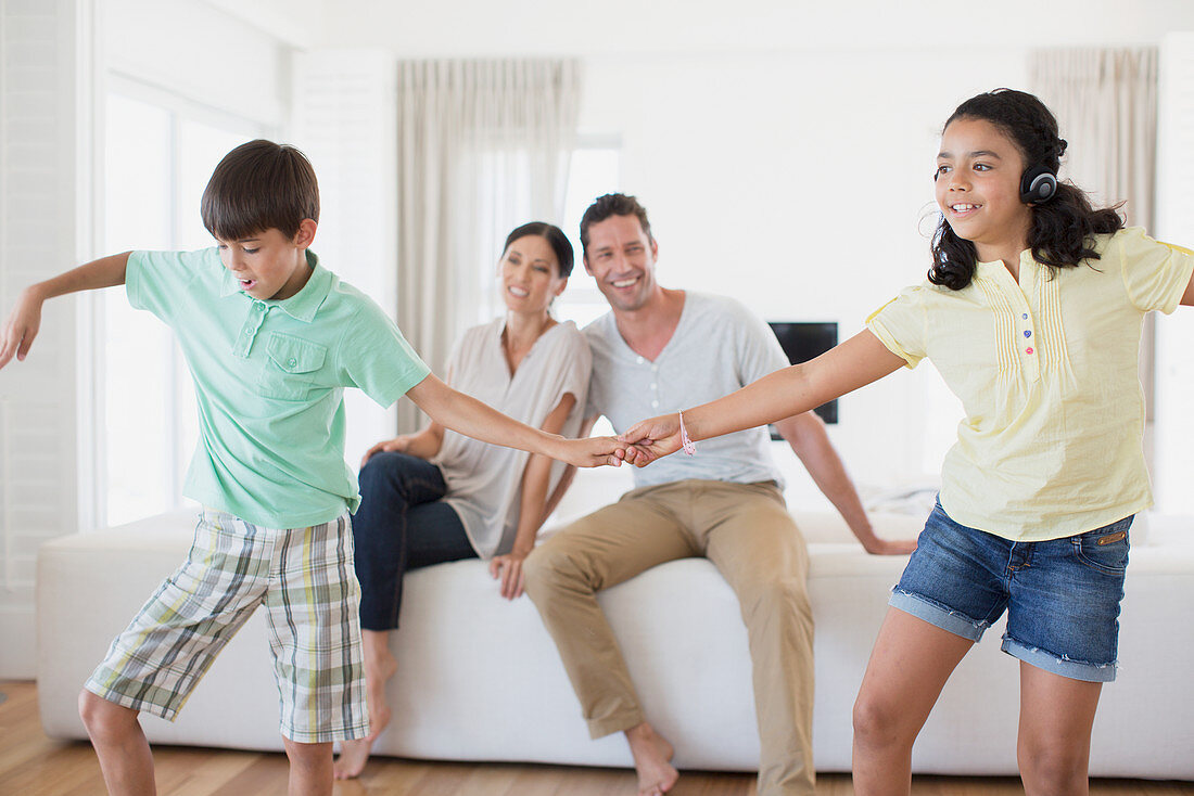 Parents watching daughter and son dancing