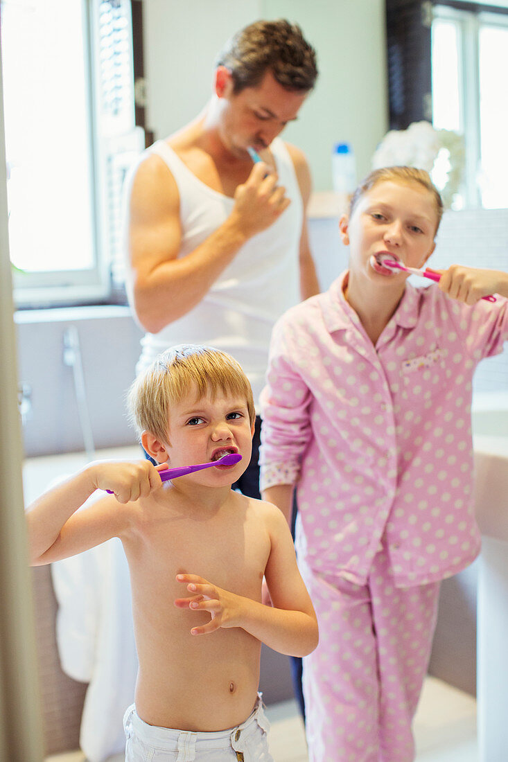 Father and children brushing teeth
