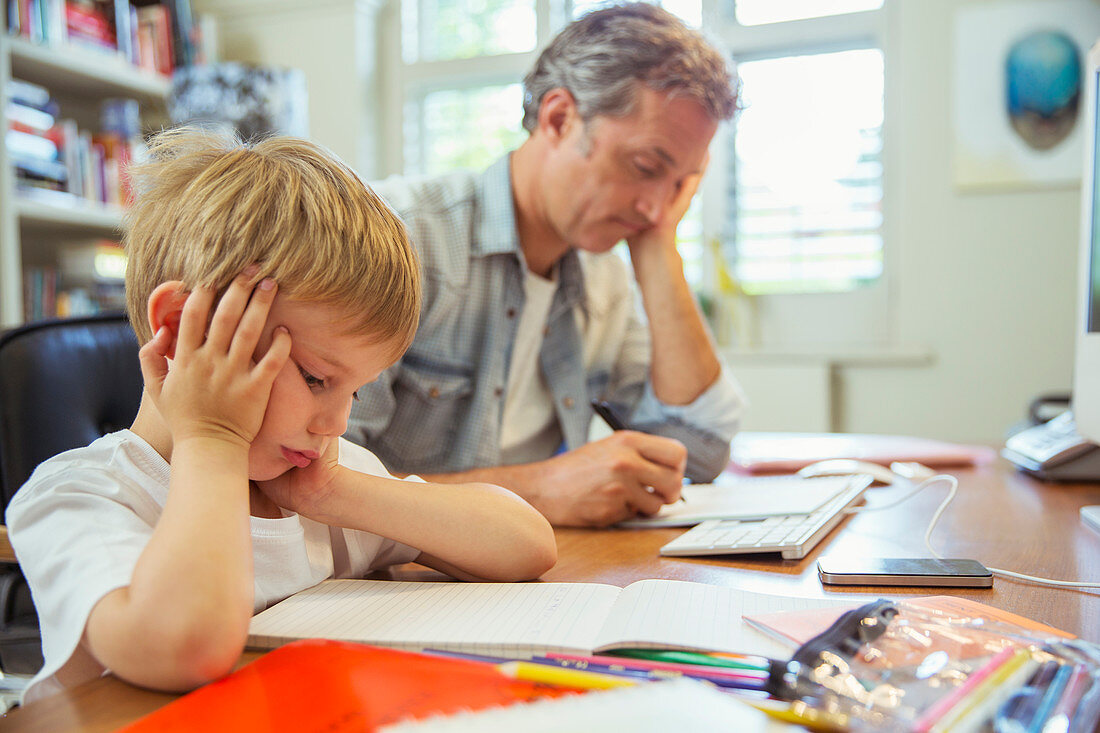 Father and son working in home office