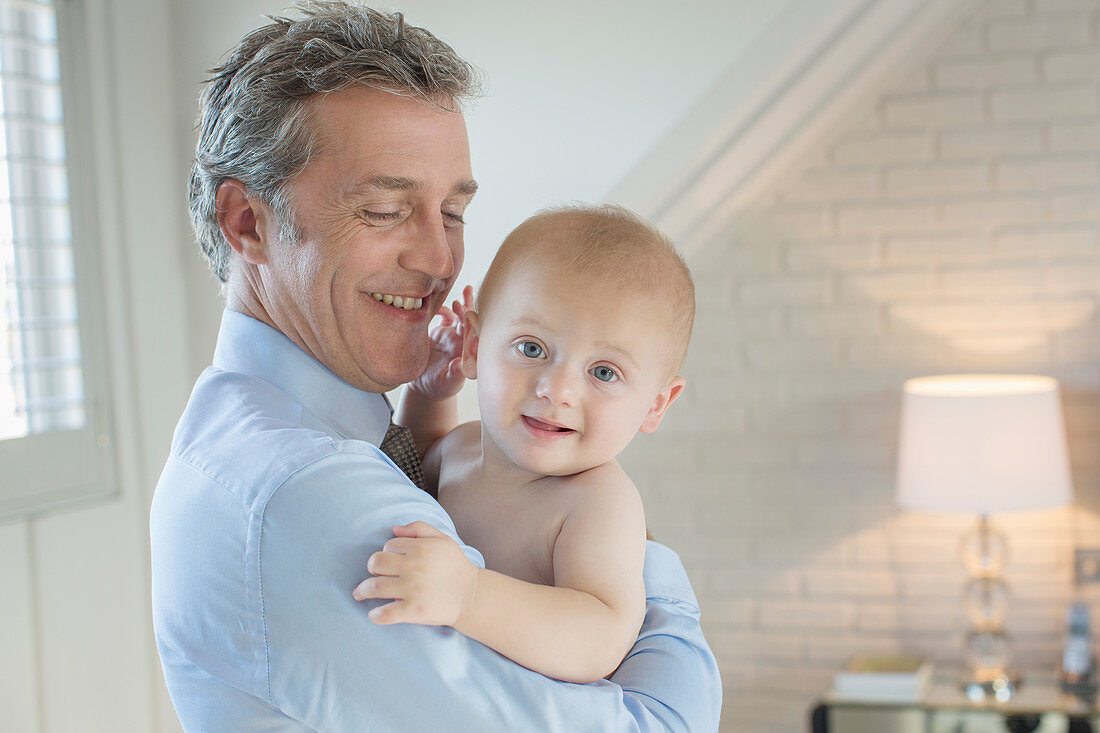 Father holding baby in bedroom