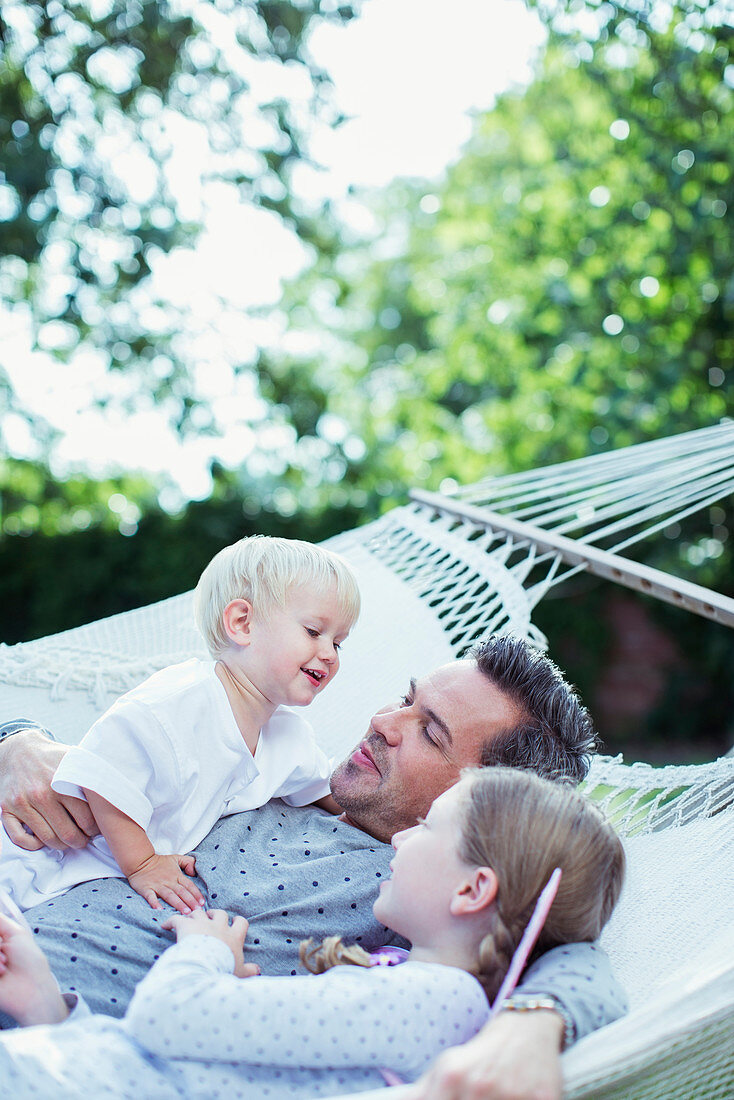 Father and children relaxing in hammock