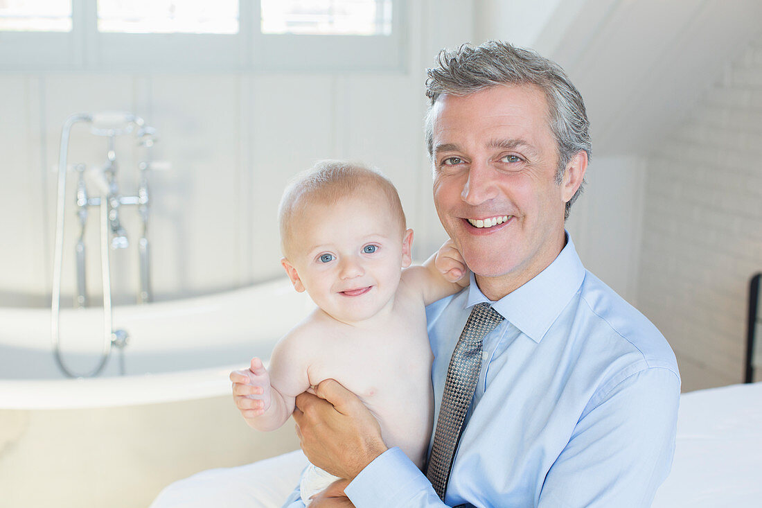 Father holding baby in bathroom