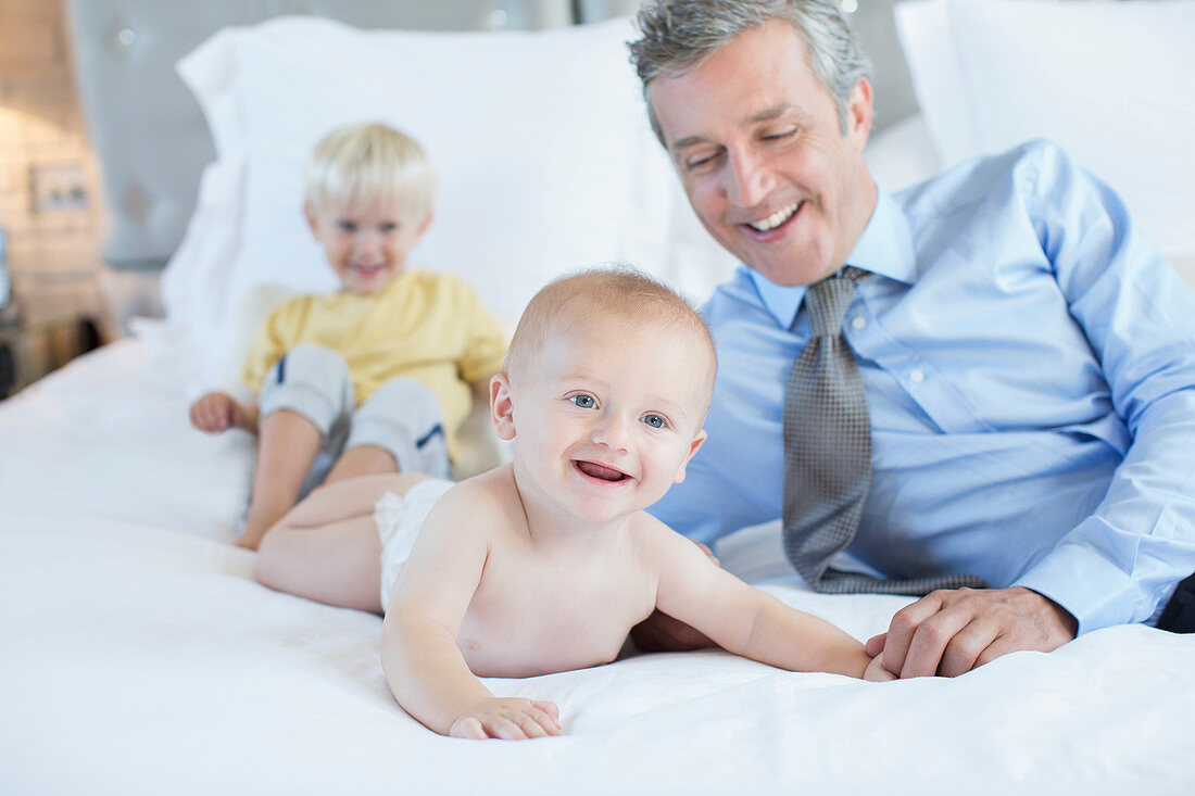 Father and children playing on bed