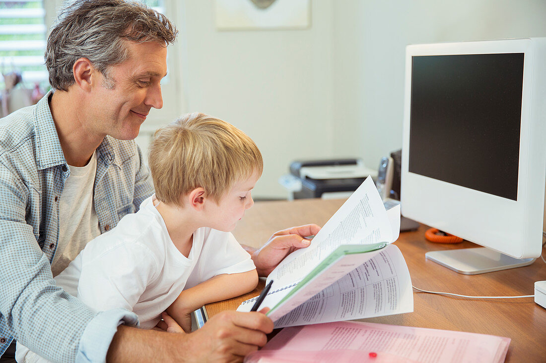 Father and son working in home office