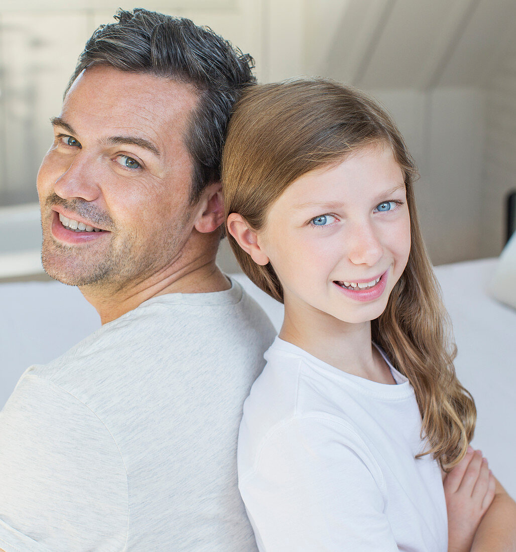 Father and daughter smiling in bedroom