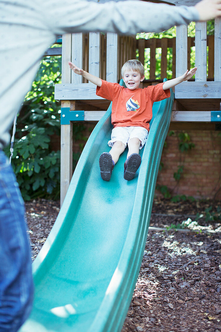 Father catching son on slide