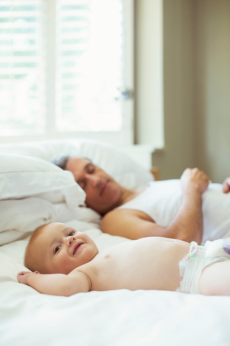 Father and baby relaxing on bed