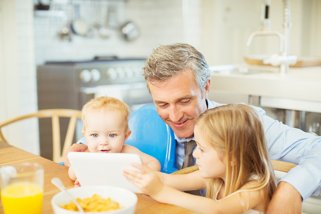 Father and children using digital tablet