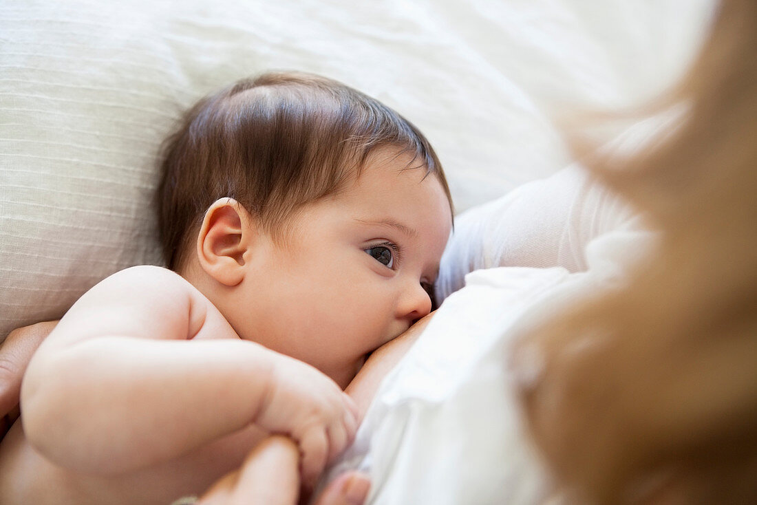 Mother breast-feeding baby girl