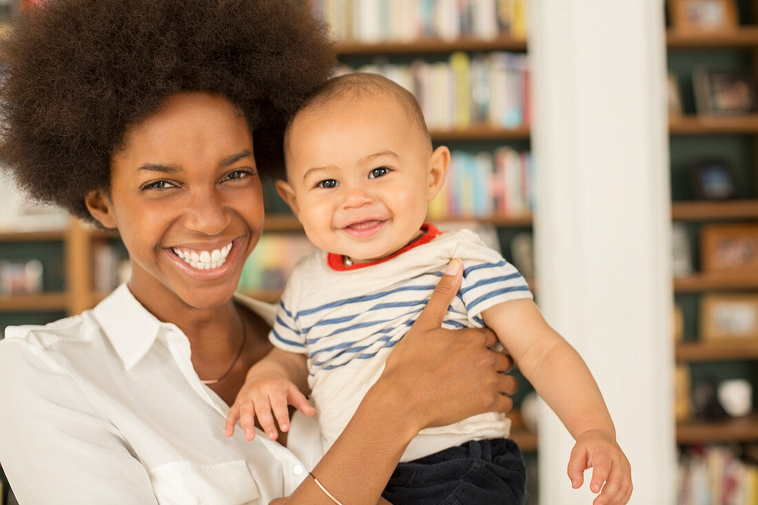 Mother holding baby boy in living room