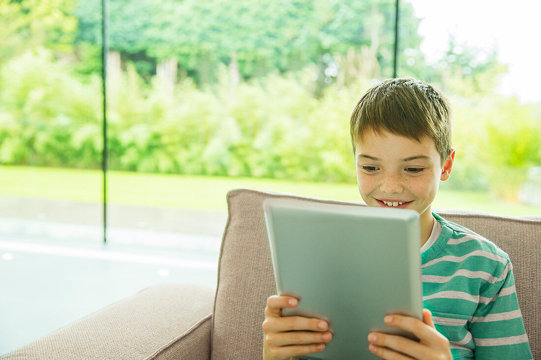 Boy using digital tablet in living room