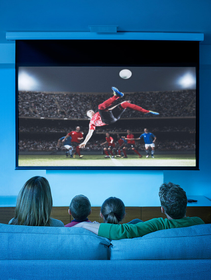 Family watching television in living room