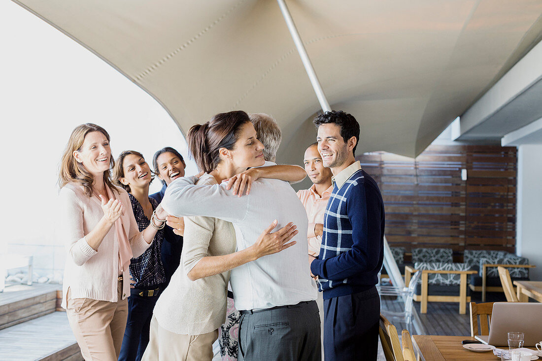 Business people hugging in office