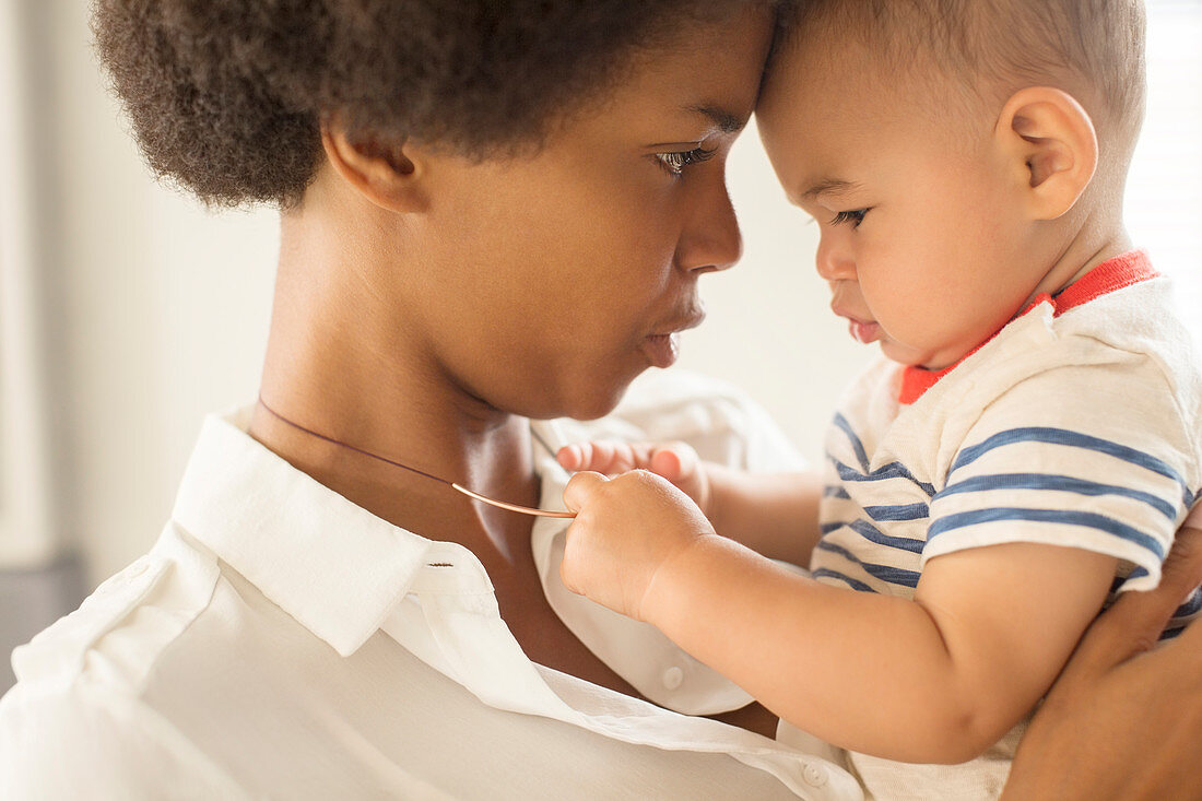 Baby boy playing with mother's necklace