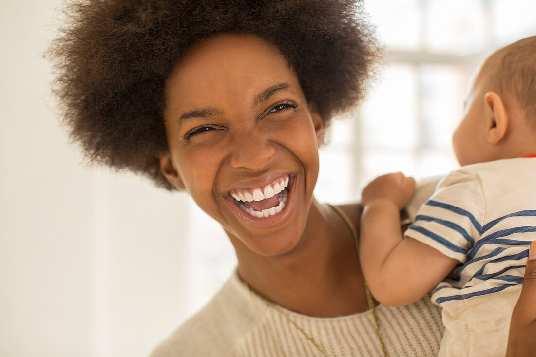 Laughing mother holding baby boy