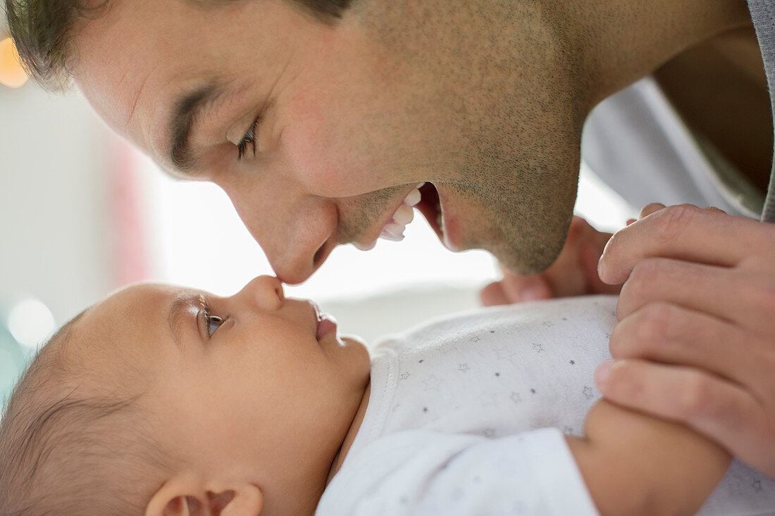 Father rubbing noses with baby boy