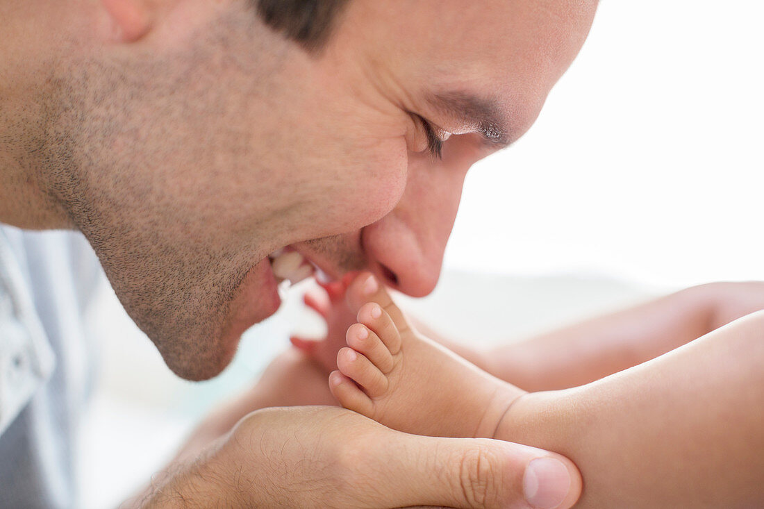 Father kissing baby boy's feet