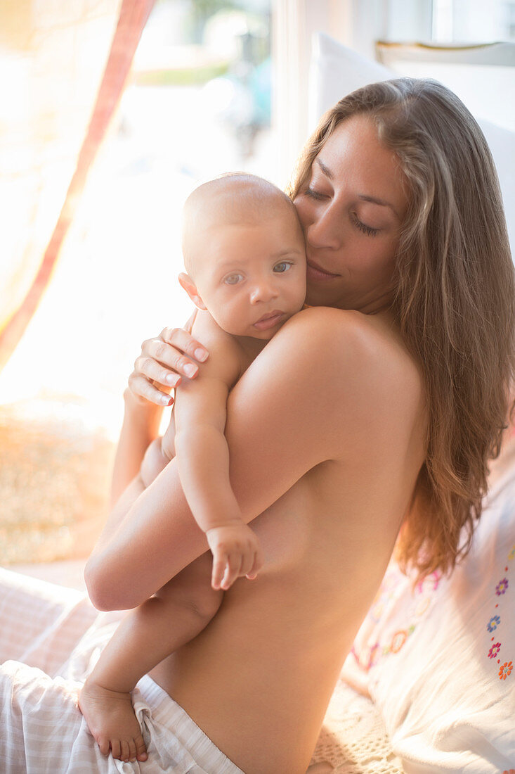 Bare chested mother holding baby boy