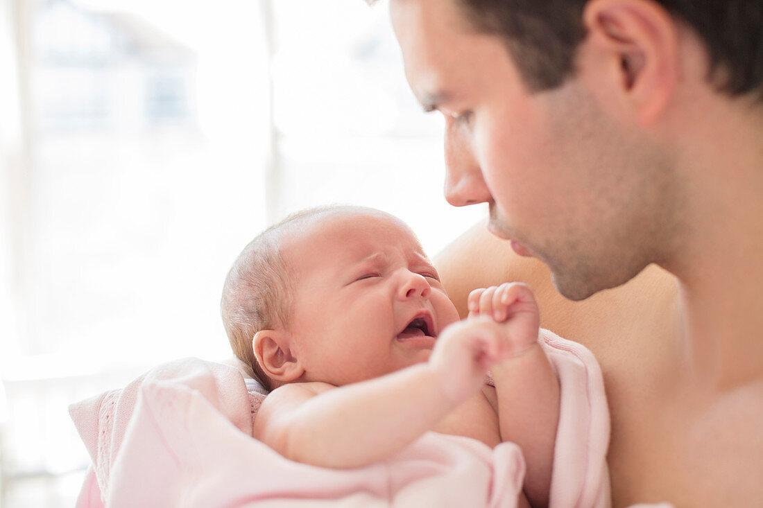 Father comforting crying baby girl