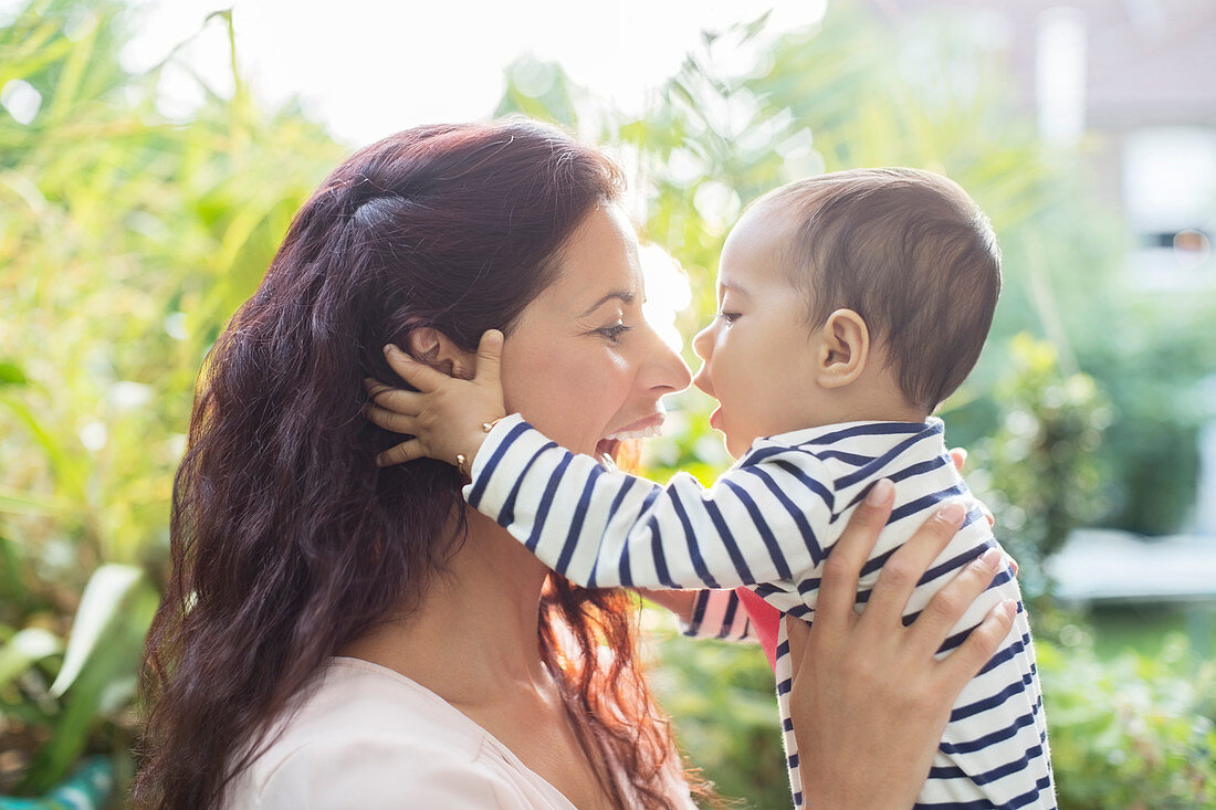 Mother holding baby girl outdoors