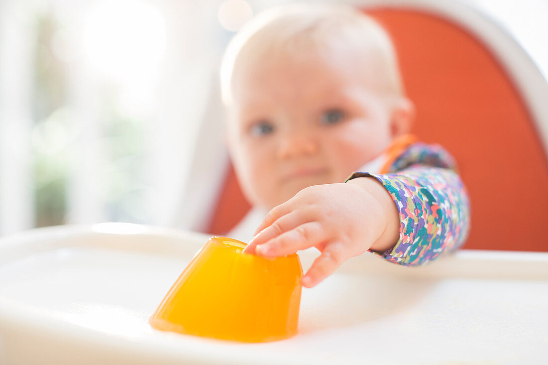 Baby girl eating in high chair