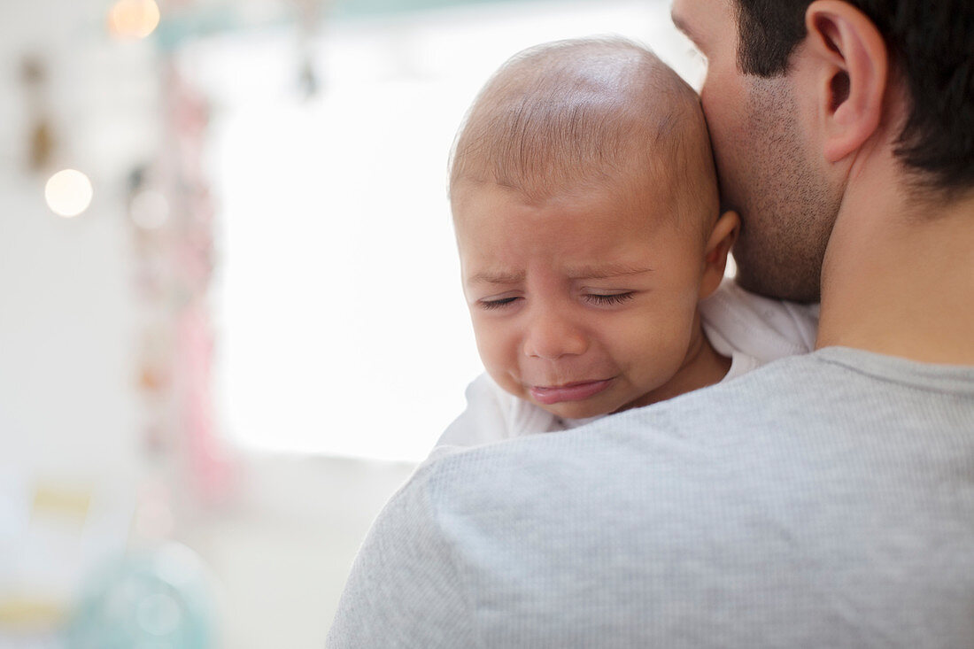 Father holding crying baby boy