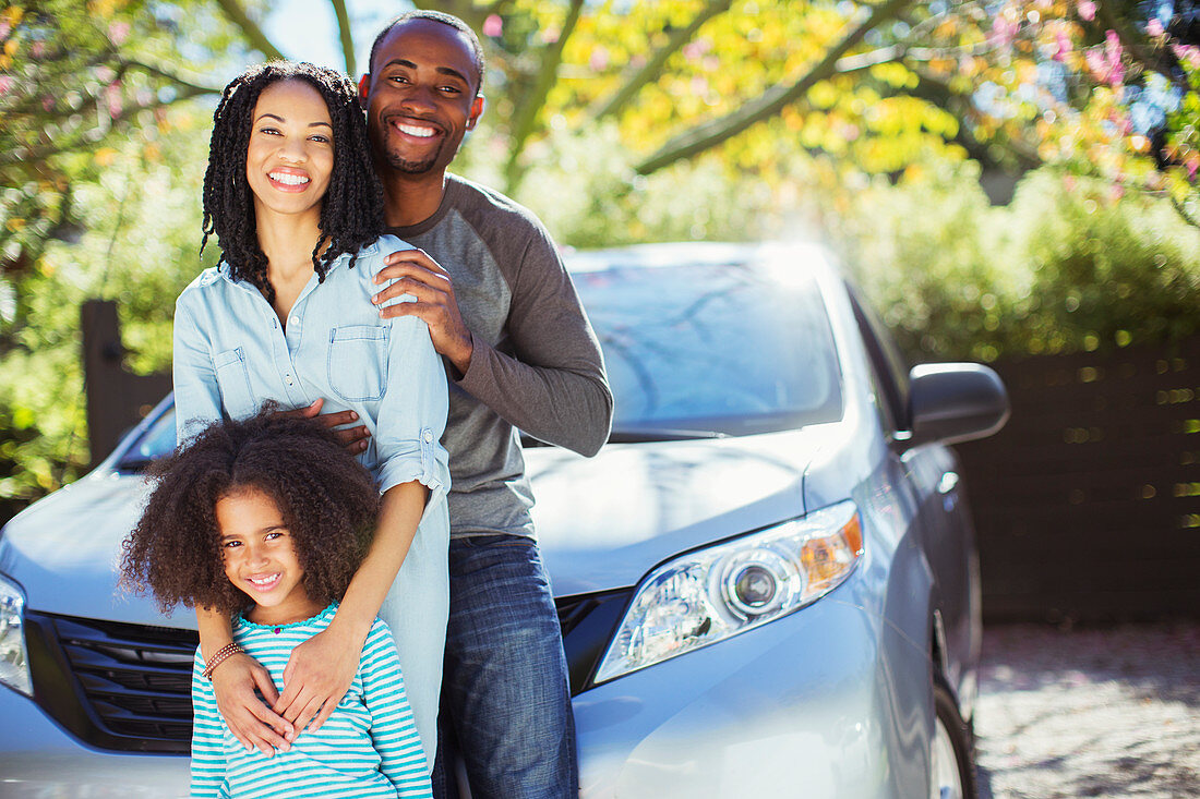 Portrait of happy family outside car