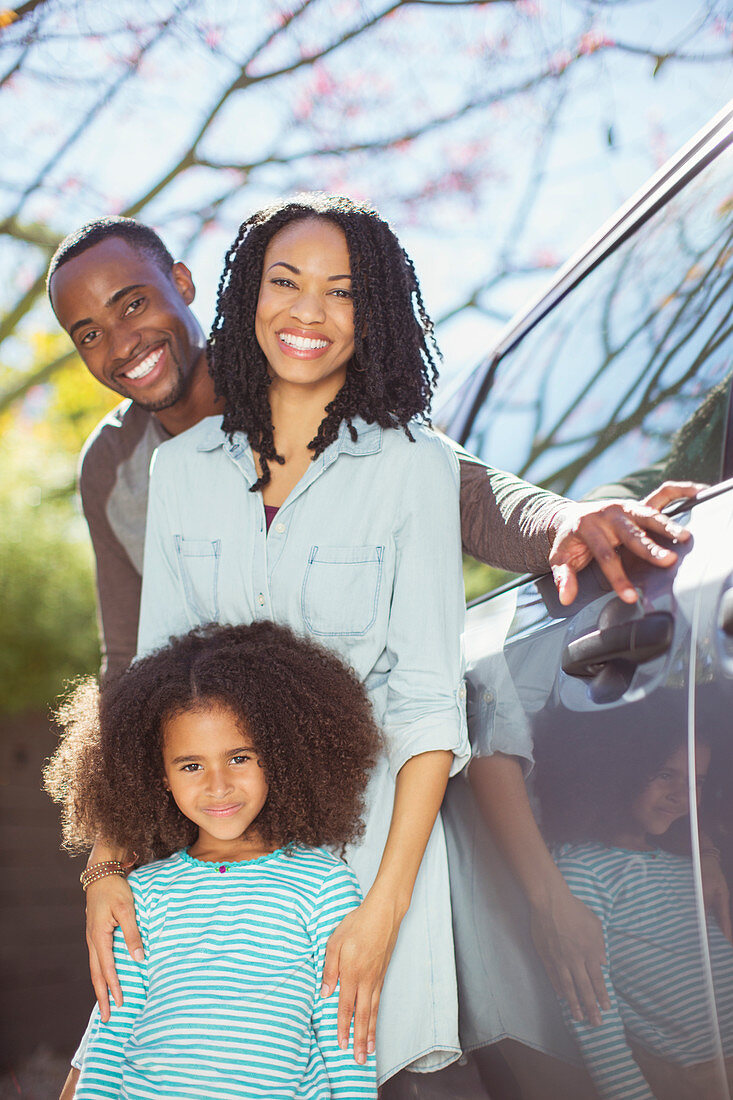 Portrait of happy family outside car