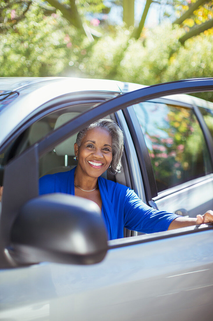 Senior woman getting out of car