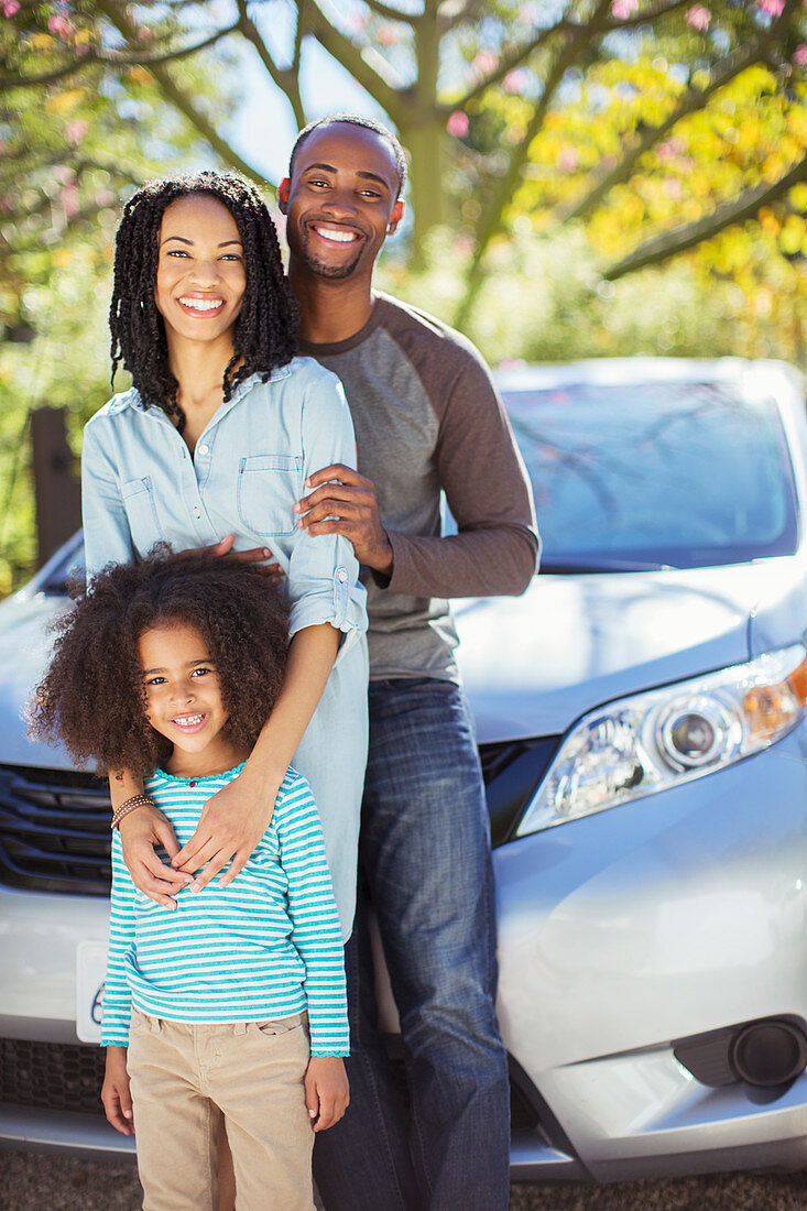 Portrait of happy family outside car