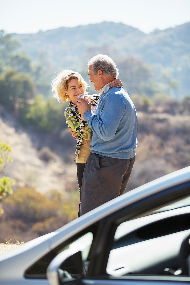 Happy senior couple dancing at roadside