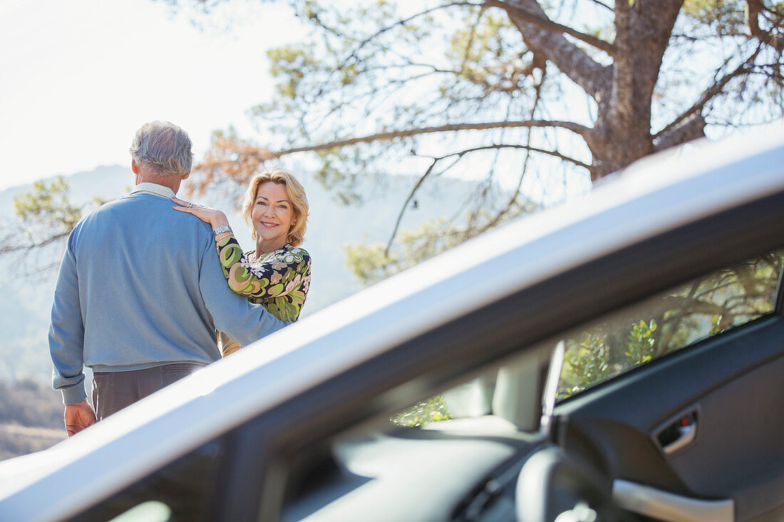 Senior couple hugging at roadside