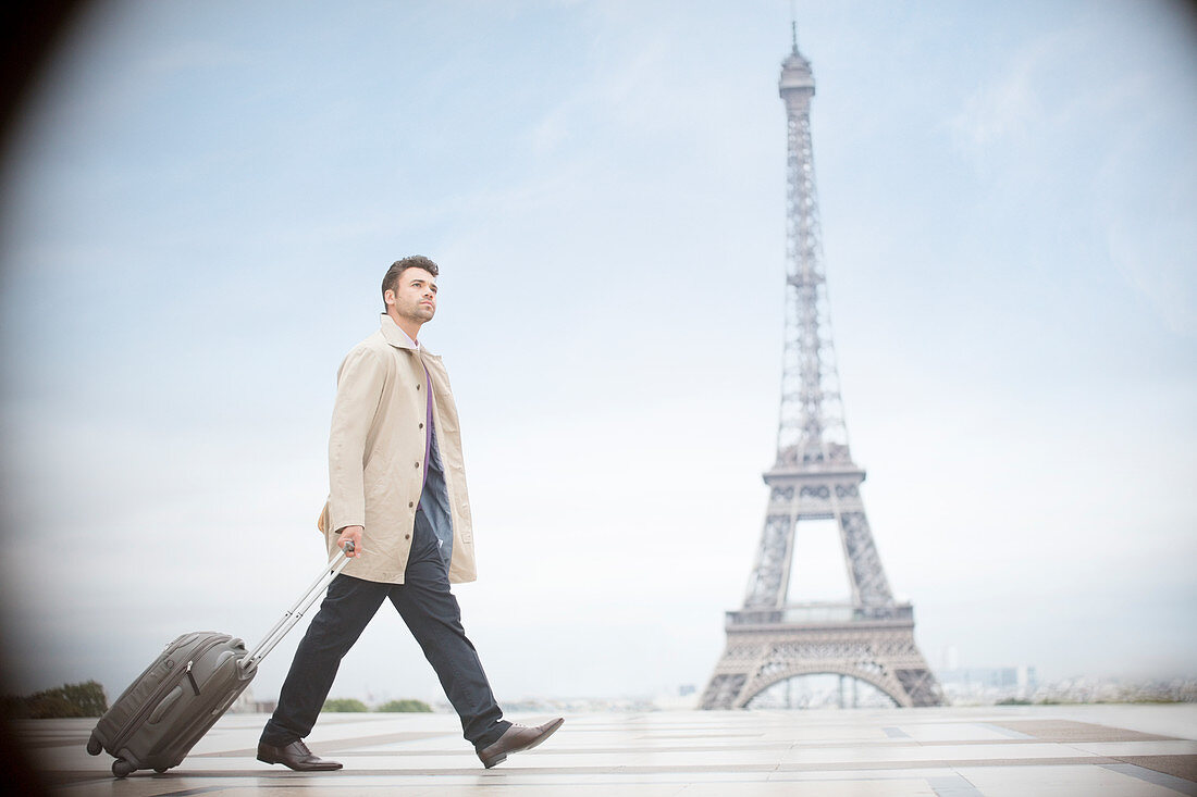 Businessman pulling suitcase in Paris
