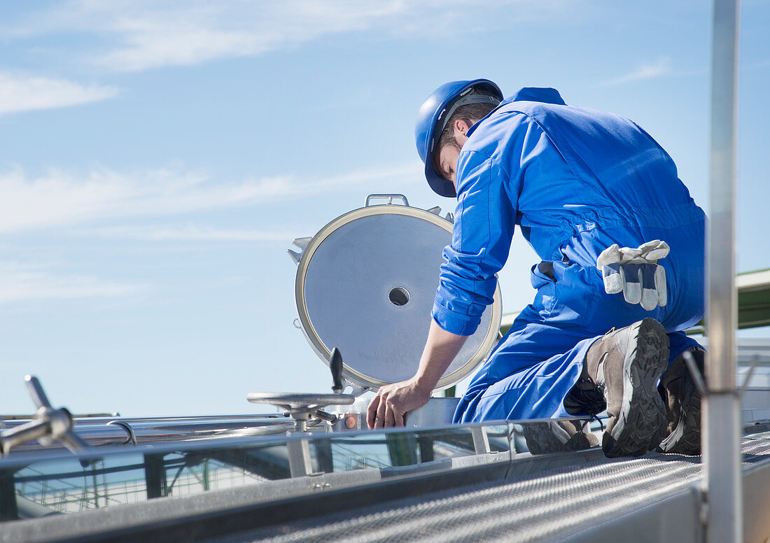 Worker looking down at milk tanker