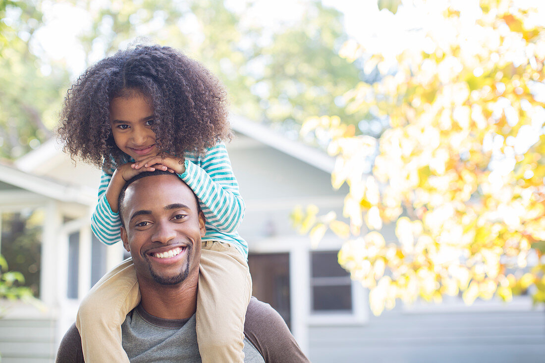 Father carrying daughter on shoulders