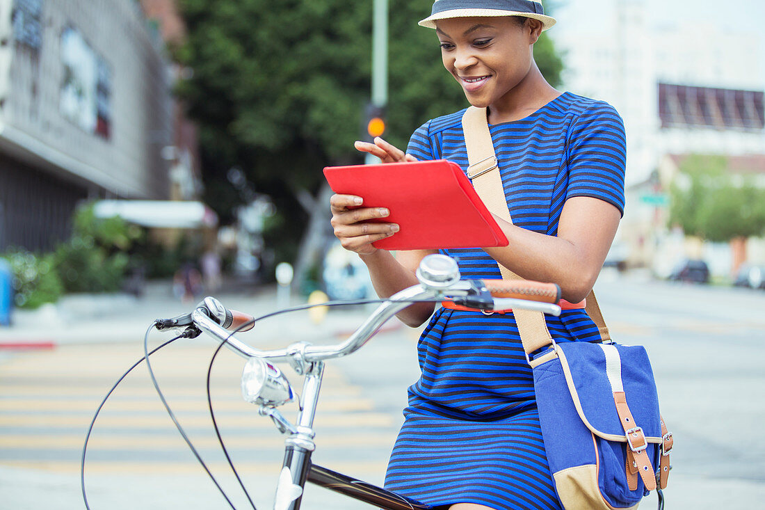 Businesswoman using tablet on bicycle