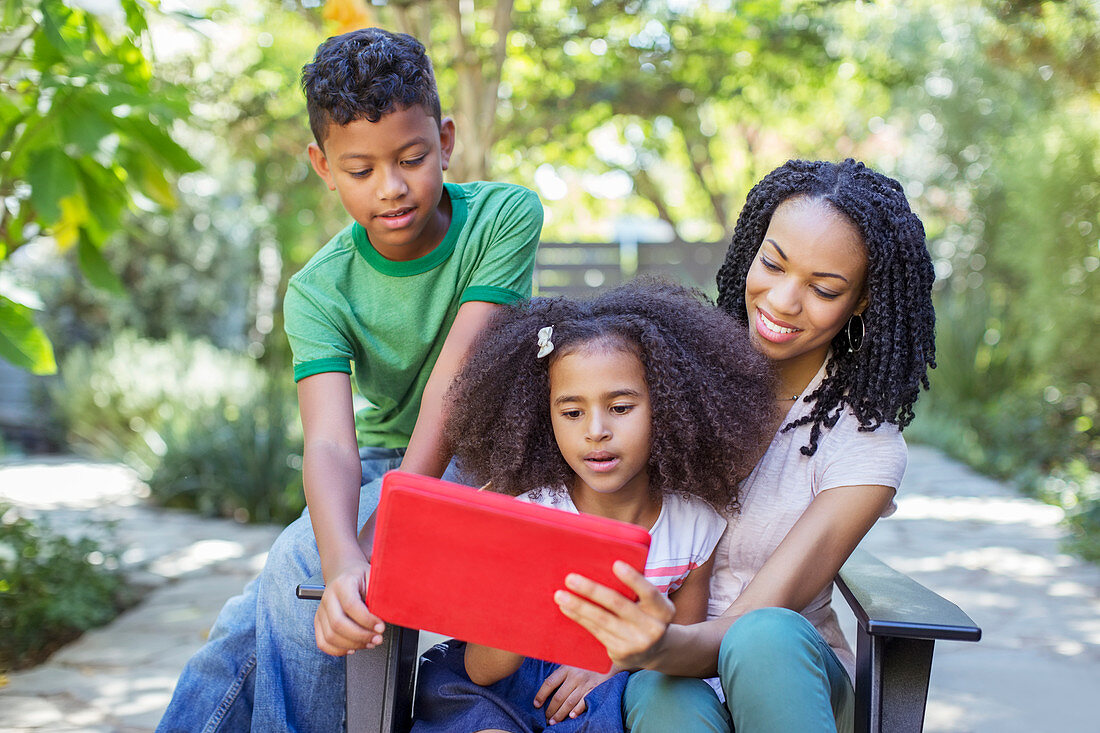 Mother and children using digital tablet