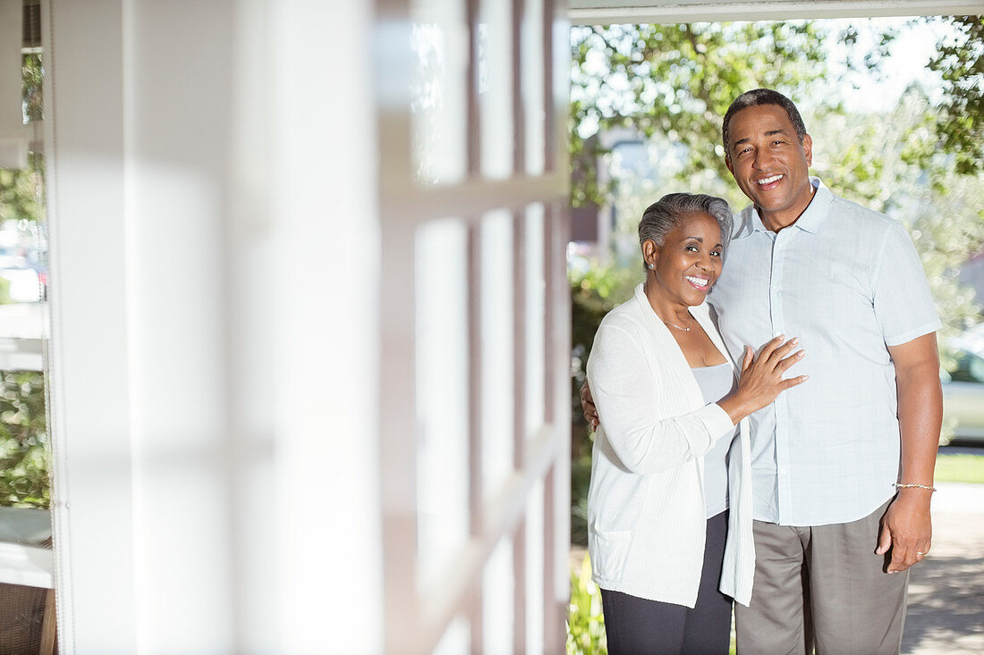 Smiling senior couple in doorway