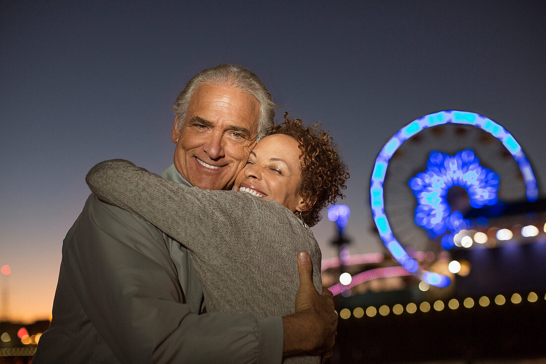 Couple hugging outside amusement park