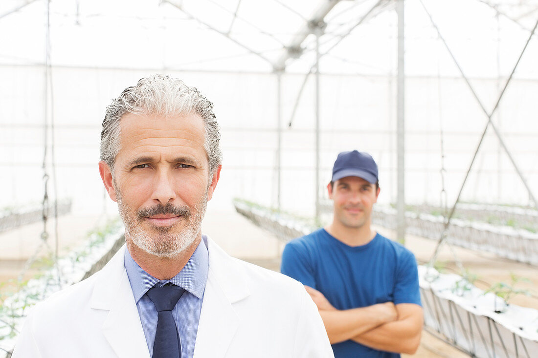 Scientist and worker in greenhouse