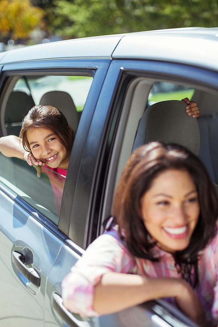 Smiling mother and daughter in car