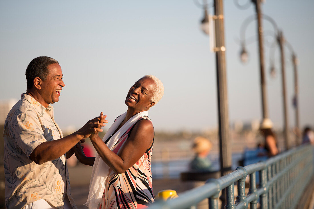 Senior couple dancing on pier