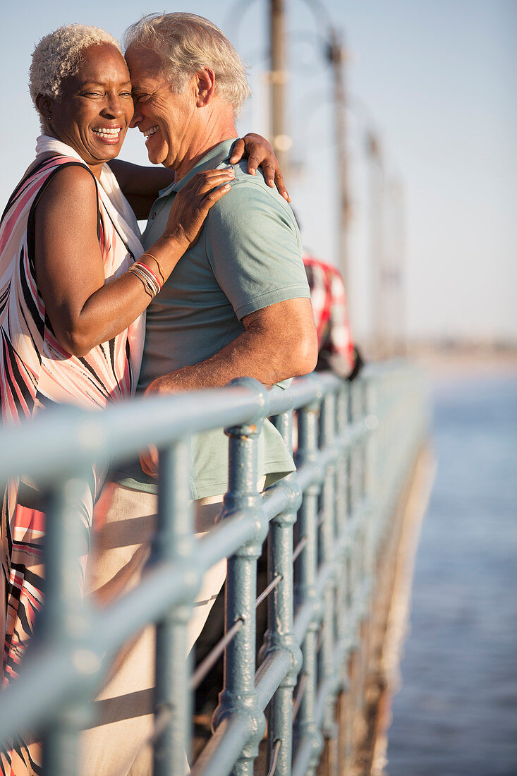 Senior couple hugging on pier