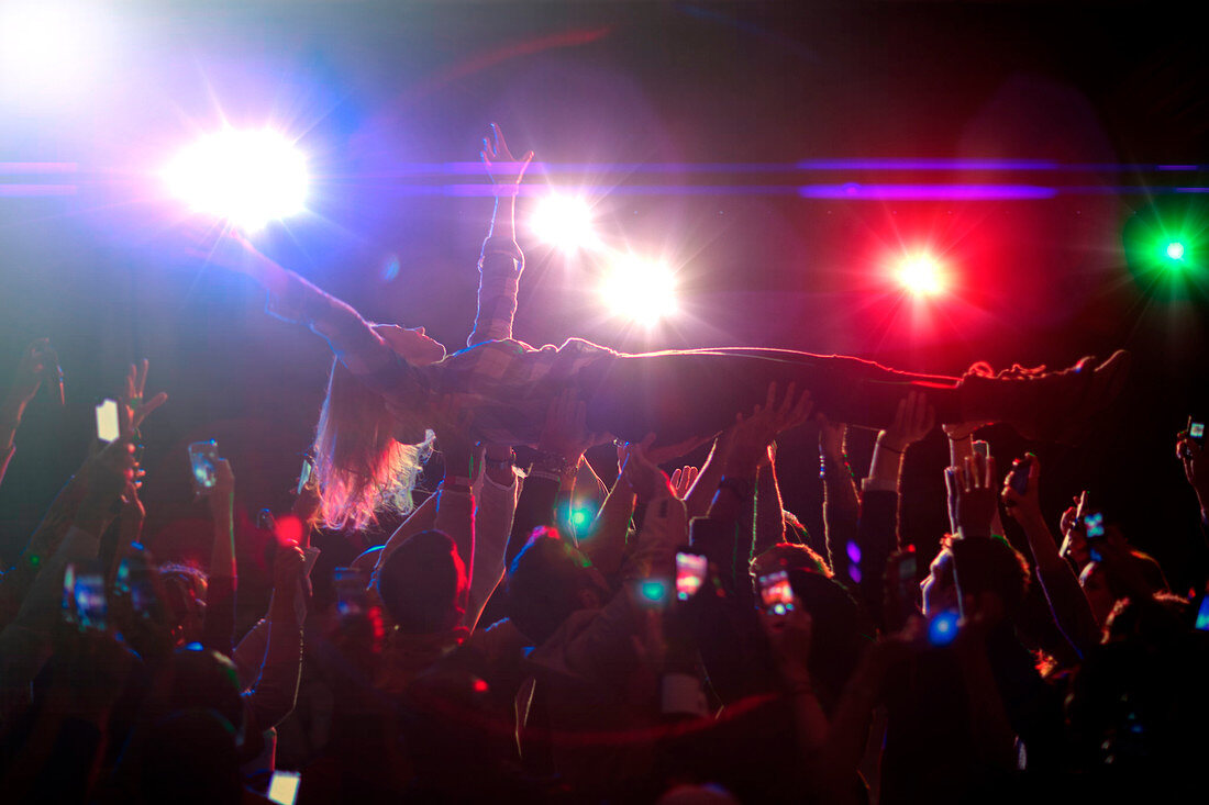 Woman crowd surfing at concert